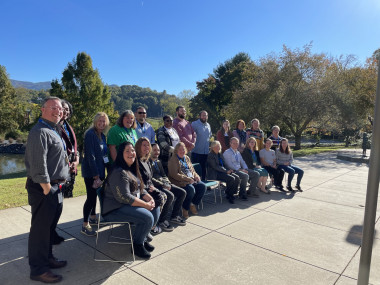 Educators getting their group photo before starting on the STEM School Rubric Educators sitting outside to have a group shot